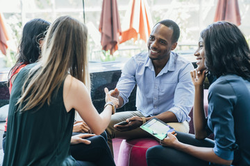 Business meeting in lobby of colorful modern office space