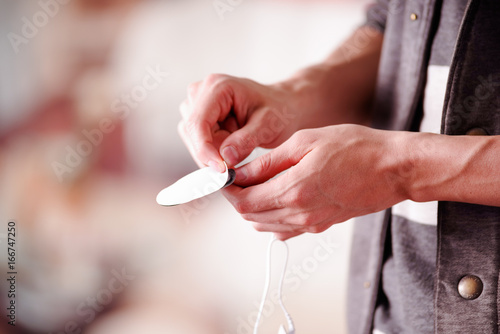 Close-up of a hand man taking out a tape of the electrostimulator electrodes in a blurred background photo