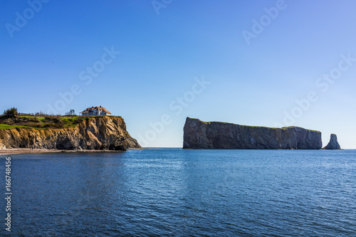 Famous Rocher Perce rock in Gaspe Peninsula, Quebec, Gaspesie region with house on cliff