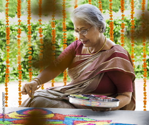 Old woman making a rangoli  photo