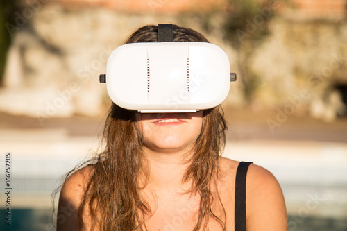 Woman with VR headset on poolside  