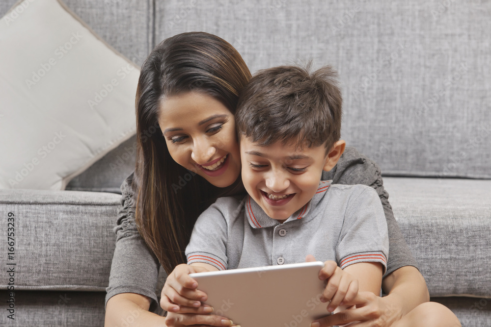 Mother and son using digital tablet at home Mother and son using digital tablet at home