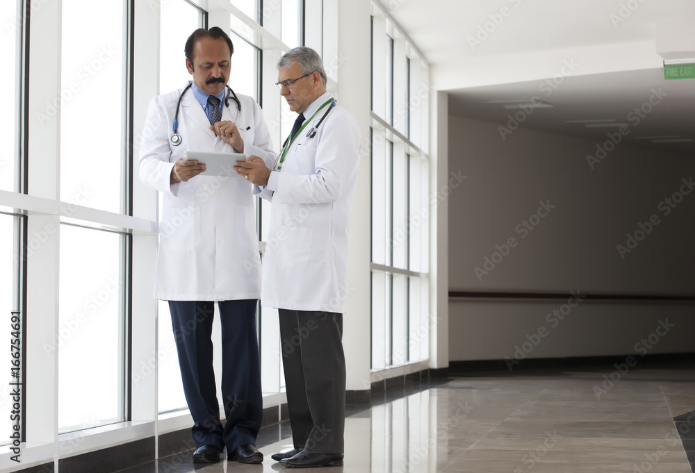Two doctors looking at a report on a digital tablet Two doctors looking at a report on a digital tablet