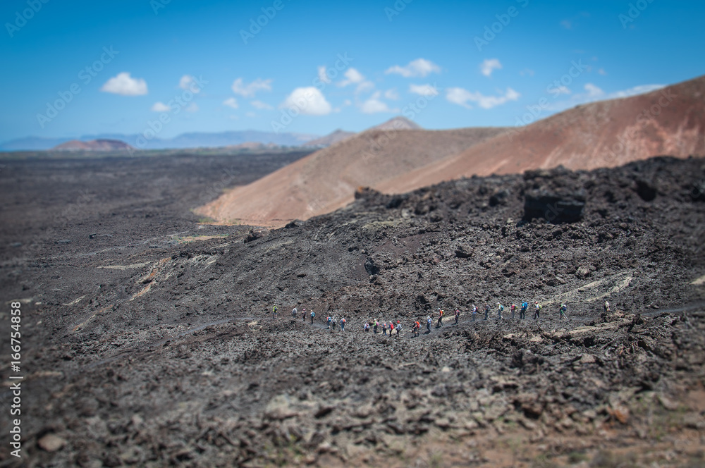 Tilt shift effetc of tourists walking on ancient lava flow, Lanzarote, Canary Islands
