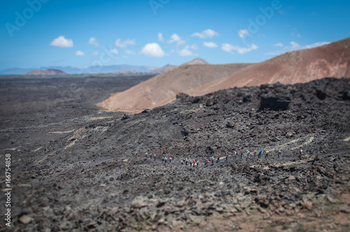 Tilt shift effetc of tourists walking on ancient lava flow, Lanzarote, Canary Islands
