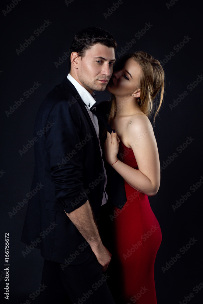Young couple in evening gown in black background Young couple in evening gown in black background