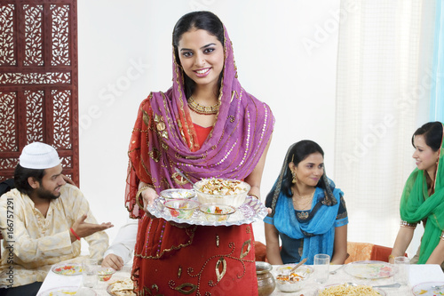 Muslim woman holding a tray with food  photo