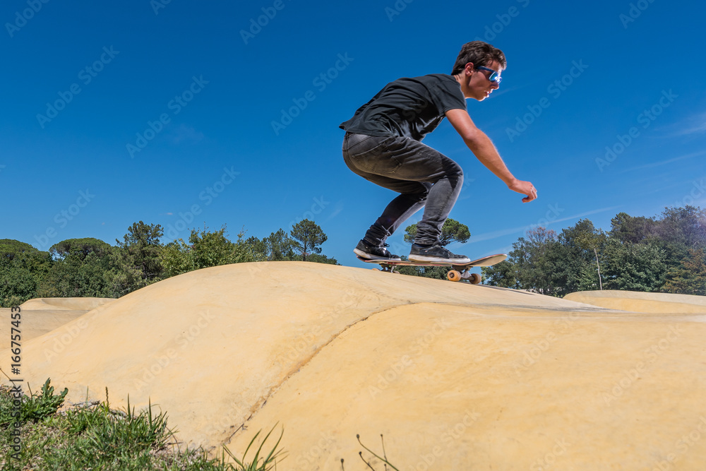 Skateboarder on a pump track park Skateboarder on a pump track park