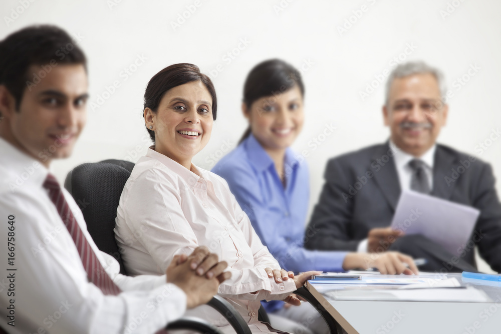 Portrait of mature businesswoman smiling with other executives Portrait of mature businesswoman smiling with other executives