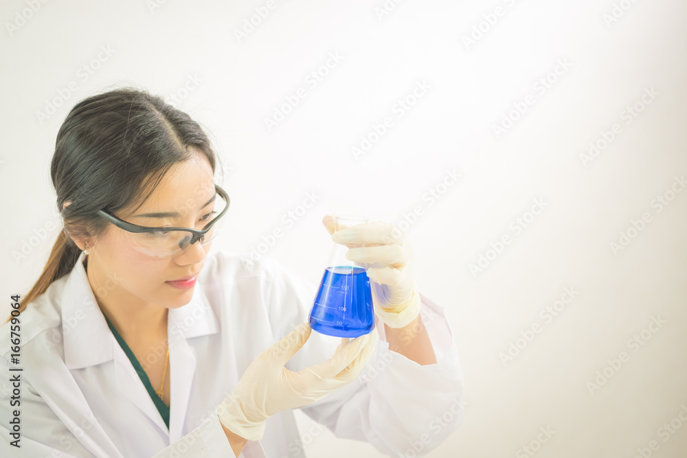 Young Asian scientist working in the lavatory with test tubes and other equipment to discover new drugs, products and methods of formulation Young Asian scientist working in the lavatory with test tubes and other equipment to discover new drugs, products and methods of formulation