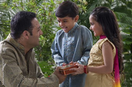 Father giving his kids chocolates  photo