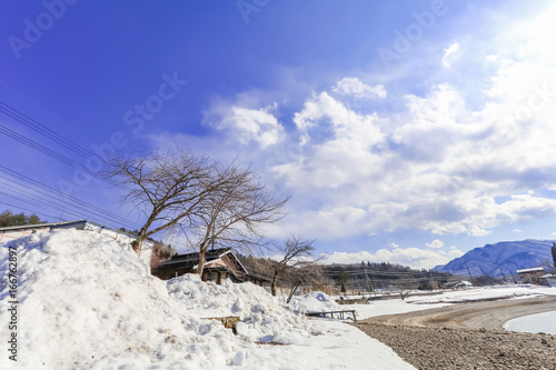 Hakuba mountain range  and Lake in the winter with snow on the mountain and blue sky and clouds background in Hakuba  Nagano Japan.