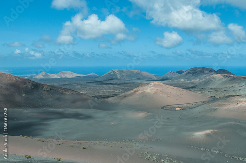 Tourist bus travelling in a road in the middle of volcanic cones, Lanzarote, Canary Islands © Gianluca