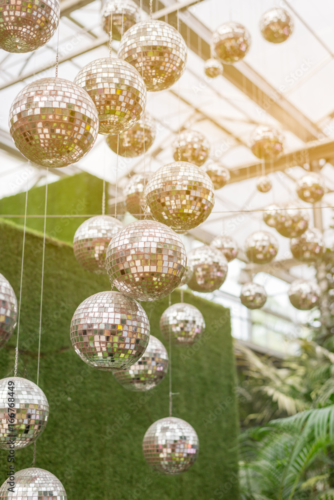 Obraz premium Disco ball hanging on ceiling under greenhouse in the sunlight