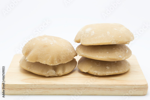 Palm sugar on wooden board, on white background photo