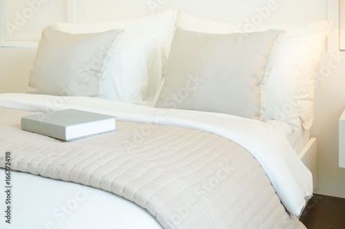 Fotografi Book on comfy bed in modern bedroom interior