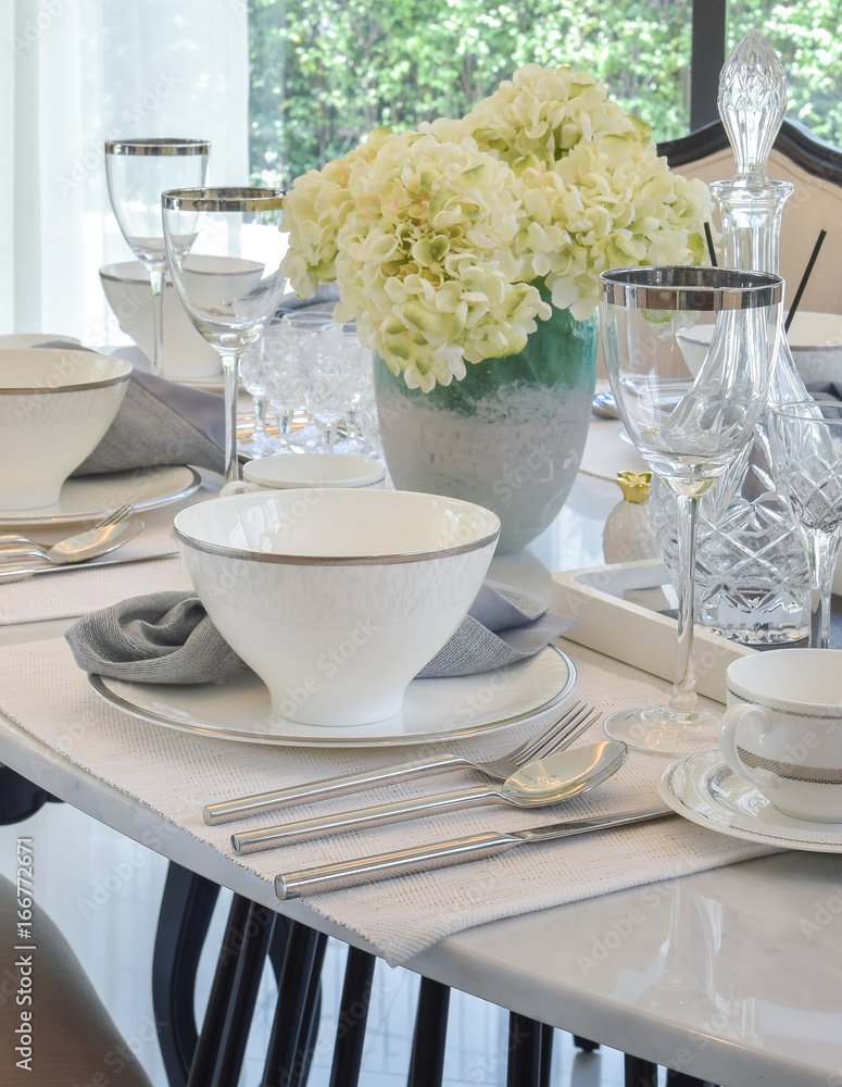 Fototapeta premium dining table and comfortable chairs in modern home with elegant table setting