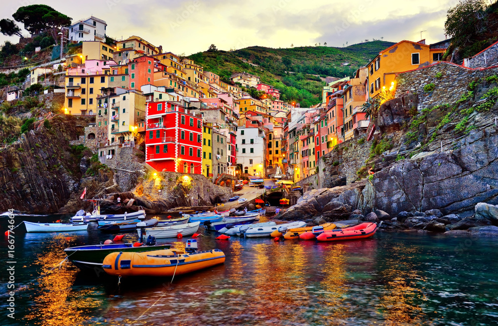 Riomaggiore village along the coastline of Cinque Terre area at sunrise in Italy.