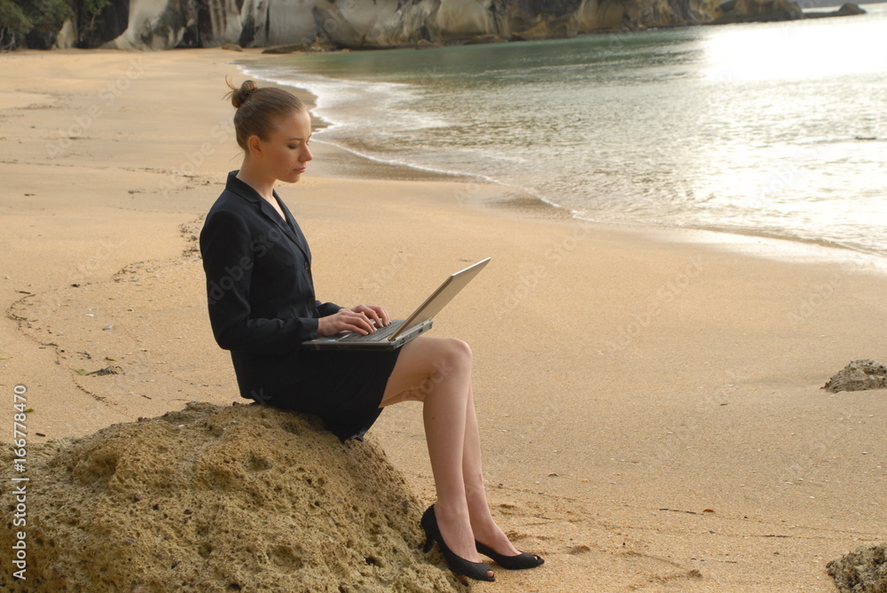 business woman working on laptop at beach