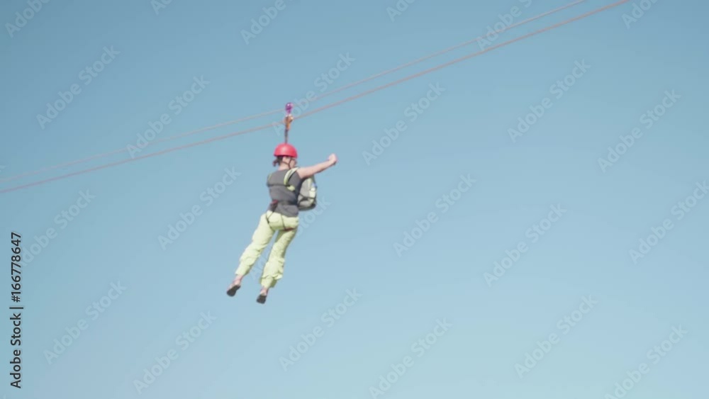 Woman riding on zipline on sunny summer day Woman riding on zipline on sunny summer day