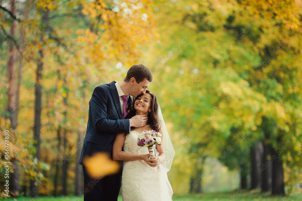 Beautiful wedding couple on a walk in autumn park Beautiful wedding couple on a walk in autumn park