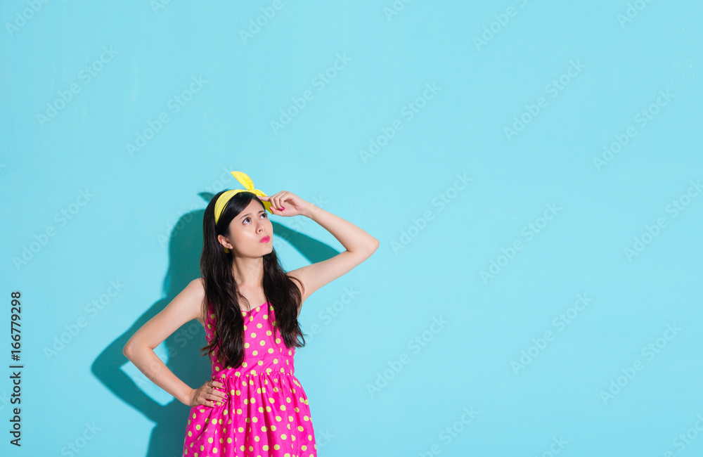 girl feeling confused standing in blue background