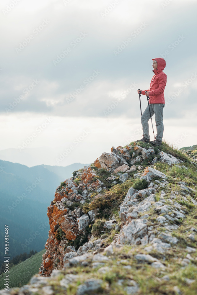 Female explorer standing on rock mountain.