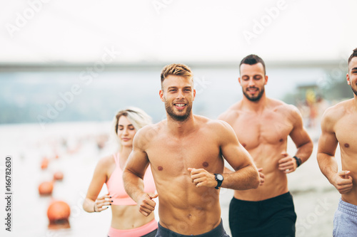 Group young attractive people having fun and running at beach.