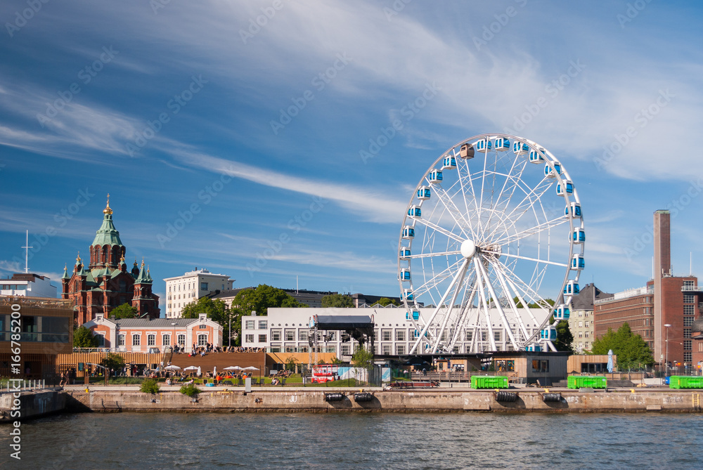 View of Helsinki harbor with Uspensky orthodox cathedral and a skywheel during a summer afternoon