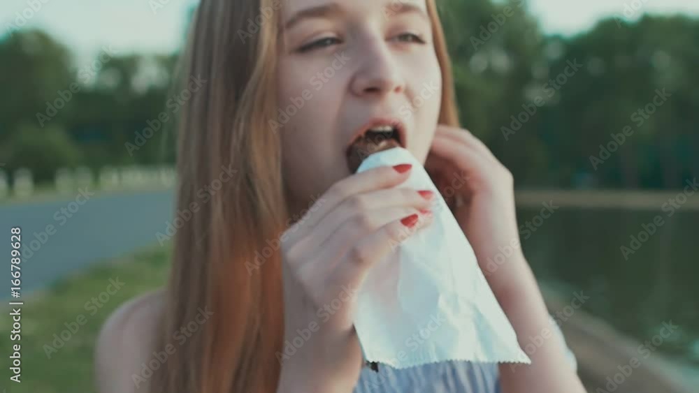 Young girl student eating chocolate bar Young girl student eating chocolate bar