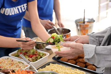 Volunteers giving food to poor people. Poverty concept