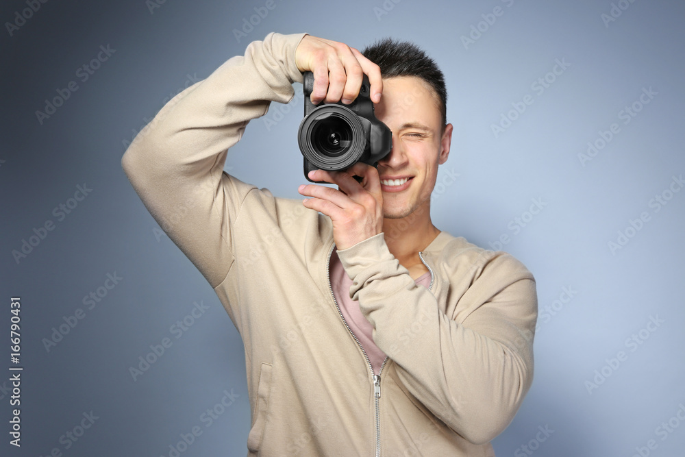 Handsome photographer with camera on light background Handsome photographer with camera on light background