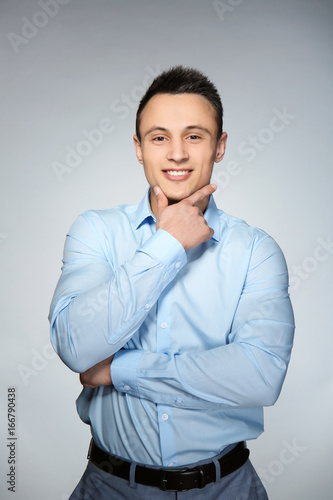 Young handsome man on gray background