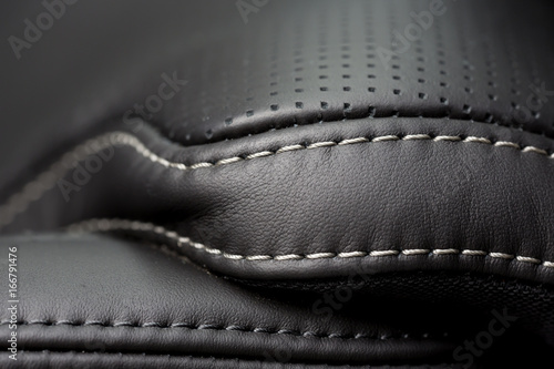 Black leather interior. Close up shot of stitches on a luxury car seat.