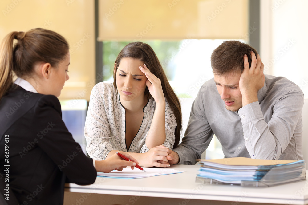 Worried customers reading a document at office Worried customers reading a document at office