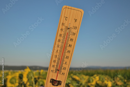 Foto Mercury wooden thermometer shows very high temperature