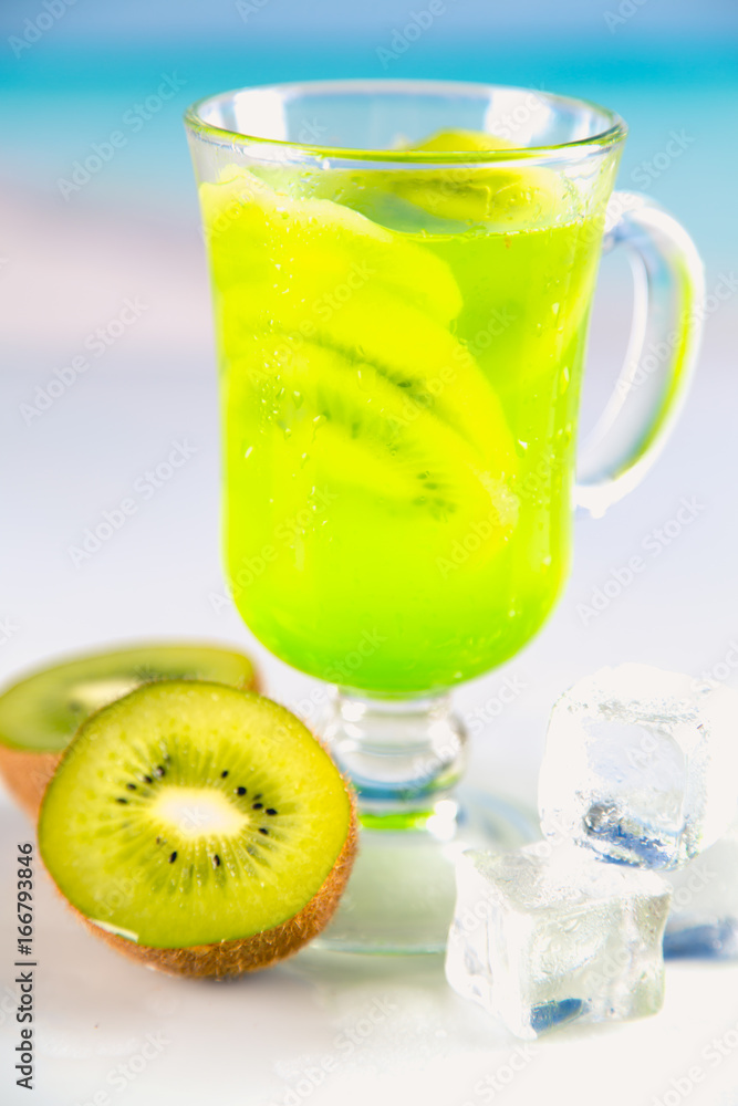 Tasty drink with kiwi on sandy beach Tasty drink with kiwi on sandy beach