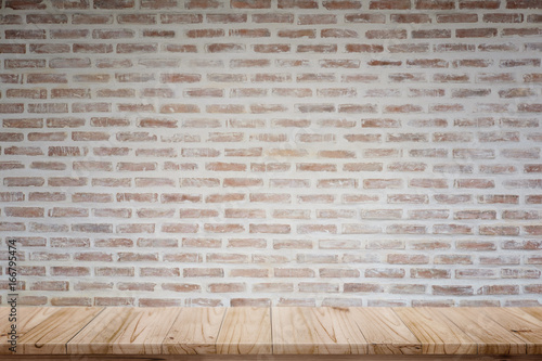 Mock up wooden table with rustic brick wall. For product display montage.
