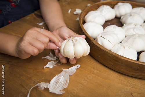 Children's hand peeling the garlic photo