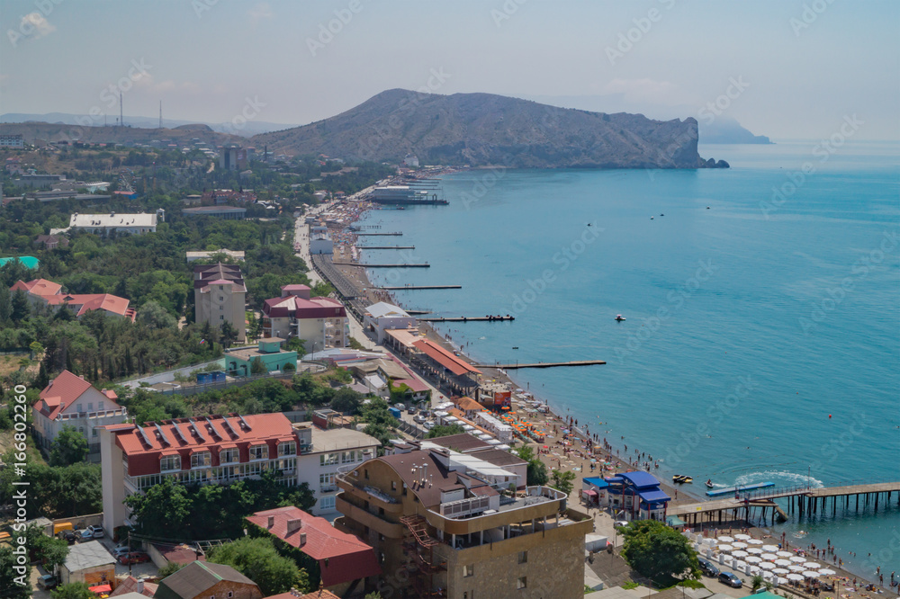 View of the seaside town Sudak in Crimea with coast, pier and sea