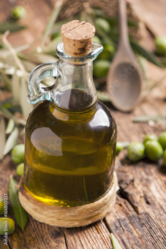 Olive oil and olives on wooden rustic table