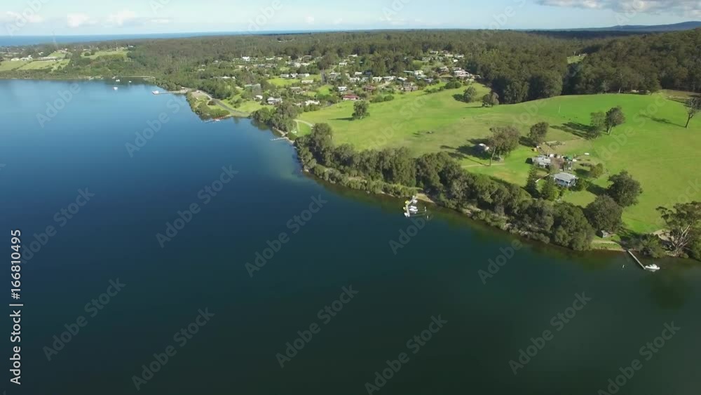 Forward flight over water towards green park on bright sunny day in Australia Forward flight over water towards green park on bright sunny day in Australia