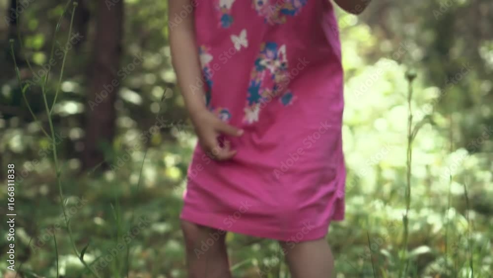 Little girl chooses strawberries in the forest and plays with her Little girl chooses strawberries in the forest and plays with her