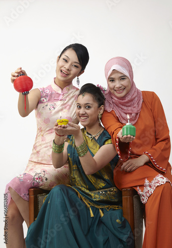 three malaysian woman holding lamp photo