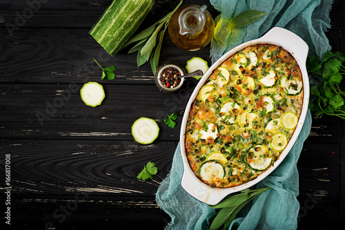 Zucchini casserole with eggs, milk, cheese and greens herbs. Flat lay. Top view