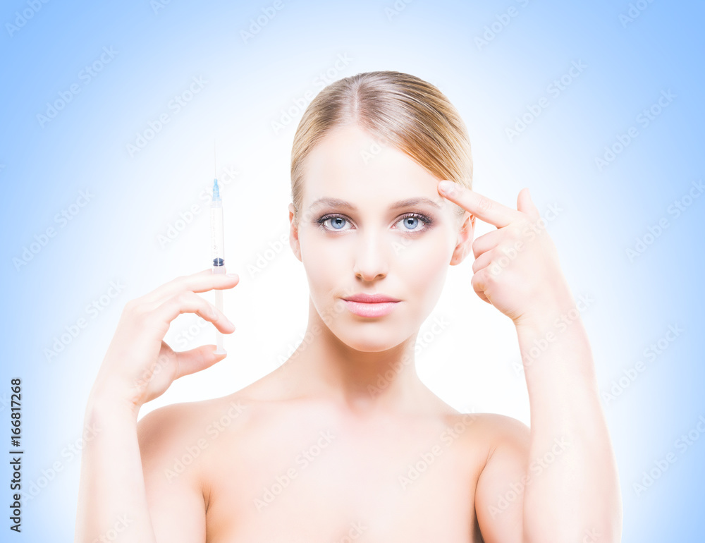 Young, beautiful and healthy woman having skin injections over blue background. Plastic surgery concept.