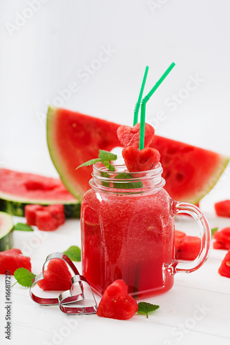 Fresh watermelon smoothies with mint on white wooden background.