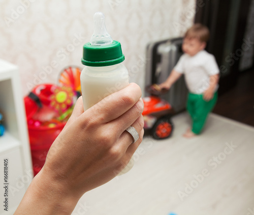 womans hand with a bottle of baby food