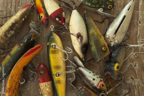 Quadro su tela Wet antique fishing lures viewed from above on a rough wood surface