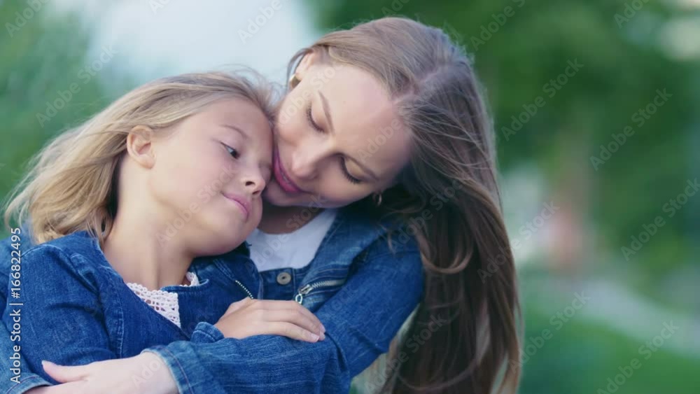 Hugging mother and daughter outdoors Hugging mother and daughter outdoors